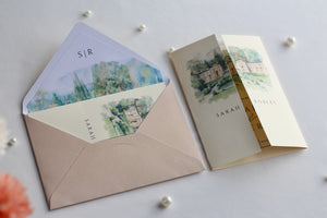 Watercolor wedding invitation suite with envelope and venue illustration detail